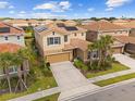 Beautiful home with lush landscaping, paver driveway, and solar panels on a sunny day at 7630 Oakmoss Loop, Davenport, FL 33837