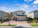 Charming two-story home featuring a brick driveway, manicured landscaping, and attached two car garage at 7702 Fairfax Dr, Kissimmee, FL 34747