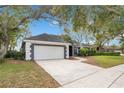 A well-maintained home with a two car garage and a driveway, perfect for parking at 827 Royalwood Ln, Oviedo, FL 32765