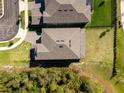 Aerial view of a well-maintained home with a modern roof, surrounded by lush greenery and neighboring properties at 11206 Pixie Mandarin Ct, Winter Garden, FL 34787