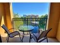 Balcony view of a community lagoon and pool area with blue skies and patio furniture at 12521 Floridays Resort Dr # 307F, Orlando, FL 32821