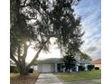 Charming single-story home with a well-maintained lawn, mature trees, and attached garage at 12538 Indiana Woods Ln, Orlando, FL 32824