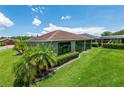 The back of a single-story home reveals manicured lawn and a screened lanai at 1368 Del Mar Dr, Kissimmee, FL 34759