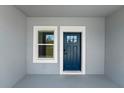 Inviting home entrance featuring a stylish blue front door and a window allowing natural light at 2415 Sw 165Th Pl, Ocala, FL 34473