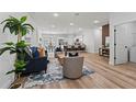 Open-concept living space with hardwood floors, stylish furniture, and a view of the kitchen at 2415 Sw 165Th Pl, Ocala, FL 34473