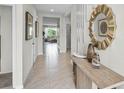 Bright hallway with tiled floors, neutral paint, and decorative mirror, leading to living areas at 2610 Grandbury Grove Rd, Lakeland, FL 33811