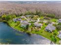 Aerial view of a lakeside home with a pool, lush greenery, and serene surroundings at 2621 Talon Ct, Orlando, FL 32837