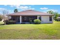 Spacious backyard featuring a large screened-in patio, green lawn, and lush landscaping at 27307 Pine Straw Rd, Leesburg, FL 34748