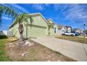 Lovely one-story home with a well-manicured lawn, two-car garage, and a light green exterior at 326 Cotswold Cir, Davenport, FL 33837