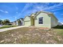 Charming one-story home with a well-maintained lawn and a light green exterior, showcasing its curb appeal at 326 Cotswold Cir, Davenport, FL 33837