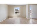 Bright, open-concept living room featuring tile floors, a large window, and a neutral color palette at 326 Cotswold Cir, Davenport, FL 33837