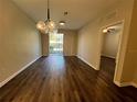 Light-filled living room boasts wood floors, updated light fixture and sliding doors to the outside at 3332 Robert Trent Jones Dr # 10703, Orlando, FL 32835