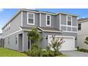 Charming gray two-story home featuring a well-maintained lawn and inviting curb appeal at 3356 Lilac Way, Davenport, FL 33897