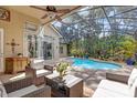 Relaxing outdoor space featuring a screened-in pool area with comfortable seating and tropical plants at 358 Woldunn Cir, Lake Mary, FL 32746