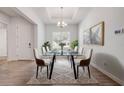 Bright dining room features modern table set with art, chandelier, trey ceiling and wood look flooring at 388 Nowell Loop, Deland, FL 32724