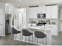 Bright kitchen features stainless steel appliances, white cabinets, and a breakfast bar with seating at 4353 Switchgrass Ln, St Cloud, FL 34772