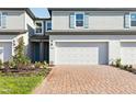 A cozy townhome with a brick driveway, garage, and tasteful landscaping at 4365 Switchgrass Ln, St Cloud, FL 34772