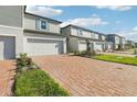 Row of modern townhomes with brick driveways, attached garages, and well-maintained lawns at 4369 Switchgrass Ln, St Cloud, FL 34772