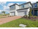 Attractive townhome featuring brick driveway, attached garage, manicured lawn, and pleasant facade at 4369 Switchgrass Ln, St Cloud, FL 34772