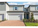 Attractive townhome featuring brick driveway, attached garage, manicured lawn, and pleasant facade at 4369 Switchgrass Ln, St Cloud, FL 34772