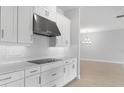 Modern white kitchen showcasing stainless steel appliances, sleek countertops, and minimalist hardware at 5641 Nevis Ter, Kissimmee, FL 34758