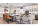 Modern kitchen with an island, stainless steel appliances, pendant lighting, and adjacent dining area at 5641 Nevis Ter, Kissimmee, FL 34758