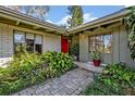 Exterior featuring a red front door, well maintained landscaping, and charming brick accents at 605 Sweetbriar Rd, Orlando, FL 32806