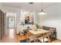 Bright dining area features hardwood flooring, light-colored wood table with four chairs and kitchen access at 660 Celebration Ave # 220, Celebration, FL 34747