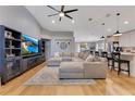 Open concept living room featuring hardwood floors, a modern ceiling fan, and a spacious sectional sofa at 703 Grand Royal Cir, Winter Garden, FL 34787