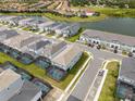 Aerial view of a residential community showcasing homes with pools and a scenic lake at 7180 Oakmoss Loop, Davenport, FL 33837