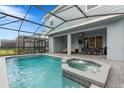 Backyard oasis featuring a pool, integrated spa, covered patio and ample seating for outdoor entertaining at 7180 Oakmoss Loop, Davenport, FL 33837