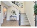 Inviting entryway featuring a staircase, tiled floors, and decorative accents at 8743 Sidley Ln, Orlando, FL 32832
