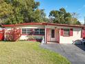 Inviting single-story home featuring a well-manicured lawn and charming red accents at 919 Timor Ave, Orlando, FL 32804