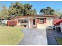Attractive single-story home with a well-kept lawn, red shutters and accents at 919 Timor Ave, Orlando, FL 32804