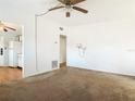 Neutral-toned living room featuring wall lighting, a ceiling fan, and doorway access to the kitchen at 919 Timor Ave, Orlando, FL 32804