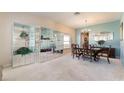 Inviting dining area with chandelier, classic wood table, and unique mirrored display cabinets at 10033 Hidden Dunes Ln, Orlando, FL 32832