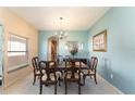 Comfortable dining room featuring wood table with six chairs, soft blue walls, and ample natural light at 10033 Hidden Dunes Ln, Orlando, FL 32832