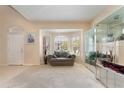 Bright living room featuring large windows, a cozy loveseat, and neutral carpeting at 10033 Hidden Dunes Ln, Orlando, FL 32832
