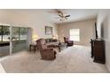 Spacious living room with comfortable seating, sliding glass doors to the patio, and a ceiling fan at 10033 Hidden Dunes Ln, Orlando, FL 32832