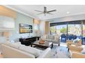 Light-filled living room with comfortable seating, a ceiling fan, and a sliding glass door to outside at 1004 Castle Pines Ct, Reunion, FL 34747