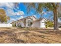 Side view of home showing mature landscaping and neutral colored exterior with white trim at 102 Ethan Ave, Davenport, FL 33897