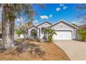 Well maintained single story home featuring a two-car garage and mature tree in the front yard at 102 Ethan Ave, Davenport, FL 33897