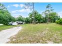 Spacious yard surrounds a single-story home with plenty of mature trees for added privacy at 1095 Grand Ave, Orange City, FL 32763