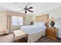 Bright bedroom featuring a plush bed, ceiling fan, and soft, beach-themed decor and a window view at 1360 Centre Court Ridge Dr # 201, Reunion, FL 34747