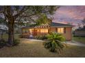 Charming single-Gathering home featuring a covered porch, mature tree, and well-maintained landscaping during twilight at 154 Pecan Dr, Ocala, FL 34472