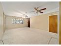 Spacious living room featuring carpet floors, neutral color paint, ceiling fans, and natural light from a large window at 154 Pecan Dr, Ocala, FL 34472
