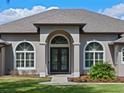 Close-up of the front entrance showcasing elegant double doors framed by arched windows and lush landscaping at 15523 Trotting Horse Ln, Tavares, FL 32778