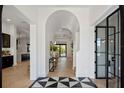 Bright foyer with herringbone wood floors, designer lighting, and an arched entryway, offering a grand welcome at 1833 Loch Berry Rd, Winter Park, FL 32789