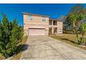 Two-story home featuring an attached garage, covered entryway, and a long concrete driveway at 1905 Snapper Dr, Kissimmee, FL 34759