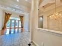 Spacious living area with tile flooring, French doors to the backyard, and elegant golden drapes at 307 Running Wind Ln, Maitland, FL 32751